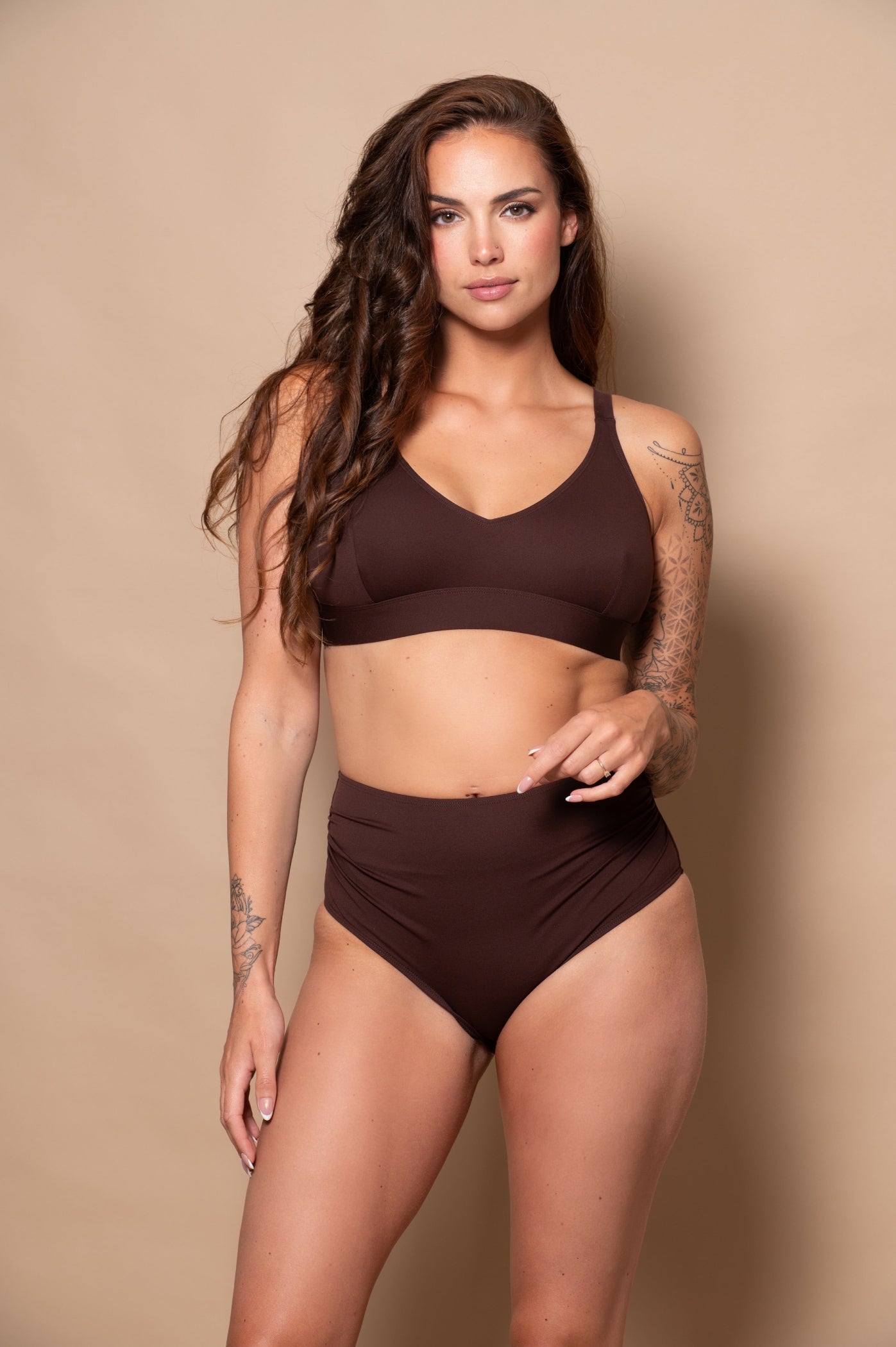 Woman wearing a brown bikini against a beige background