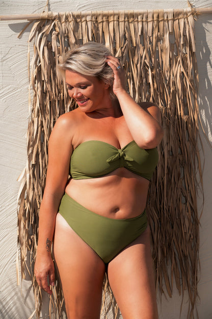 woman wearing a green khaki bikini set against a beige background