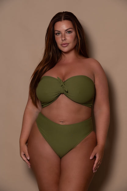 plussize woman wearing a green khaki bikini against a beige background