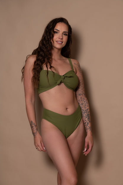 woman wearing a green khaki bikini set against a beige background
