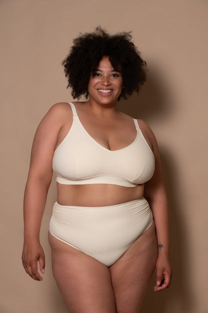 plussize woman wearing a white cream bikini  against a beige background