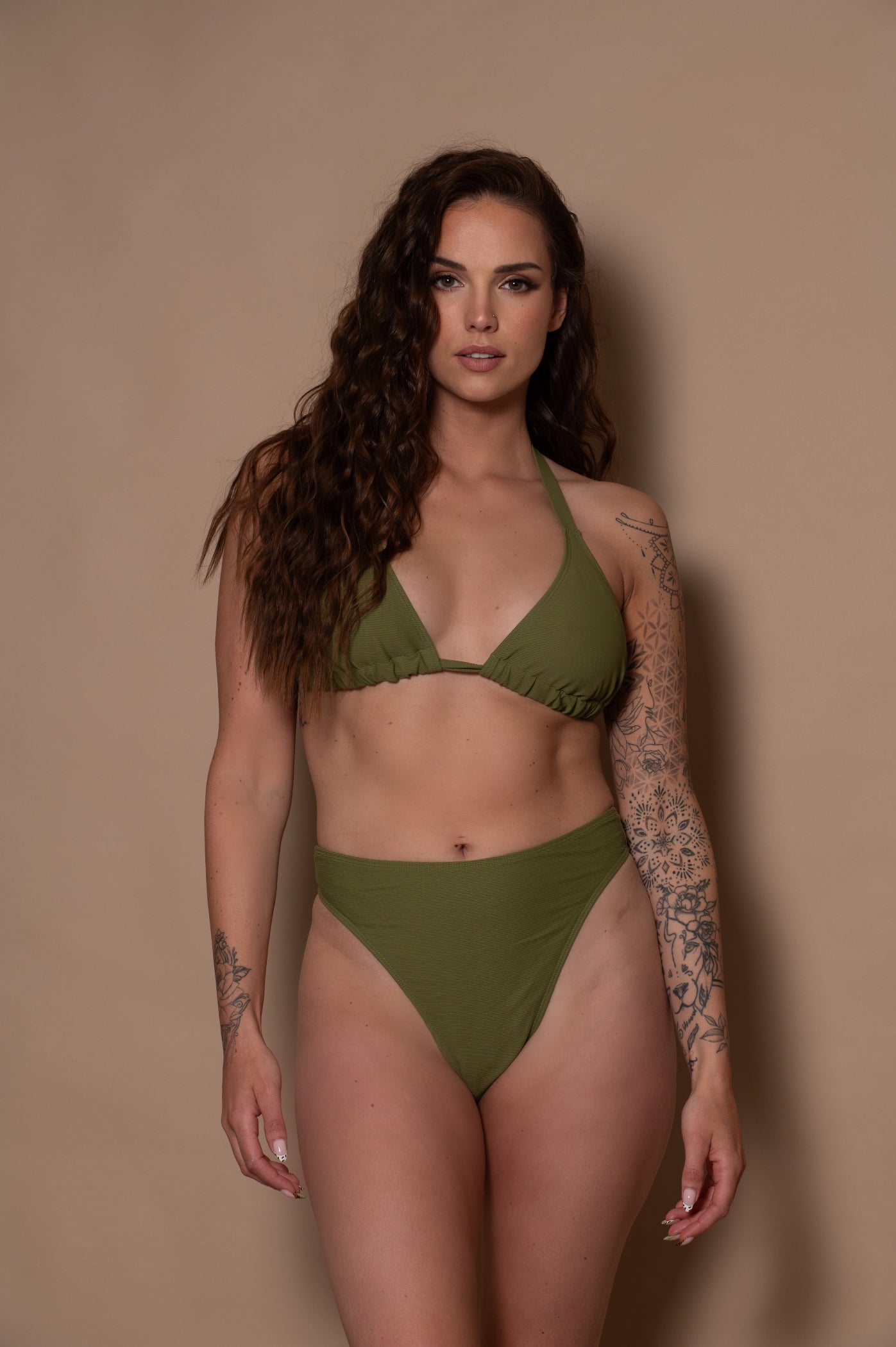 woman wearing a green khaki bikini set against a beige background