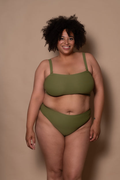 plussize woman wearing a green khaki bikini against a beige background
