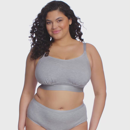 Curvy woman wearing a grey bra and underwear set against a white background