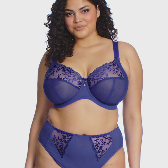 curvy woman wearing a sapphire Blue lingerie set with floral lace trim on a white background