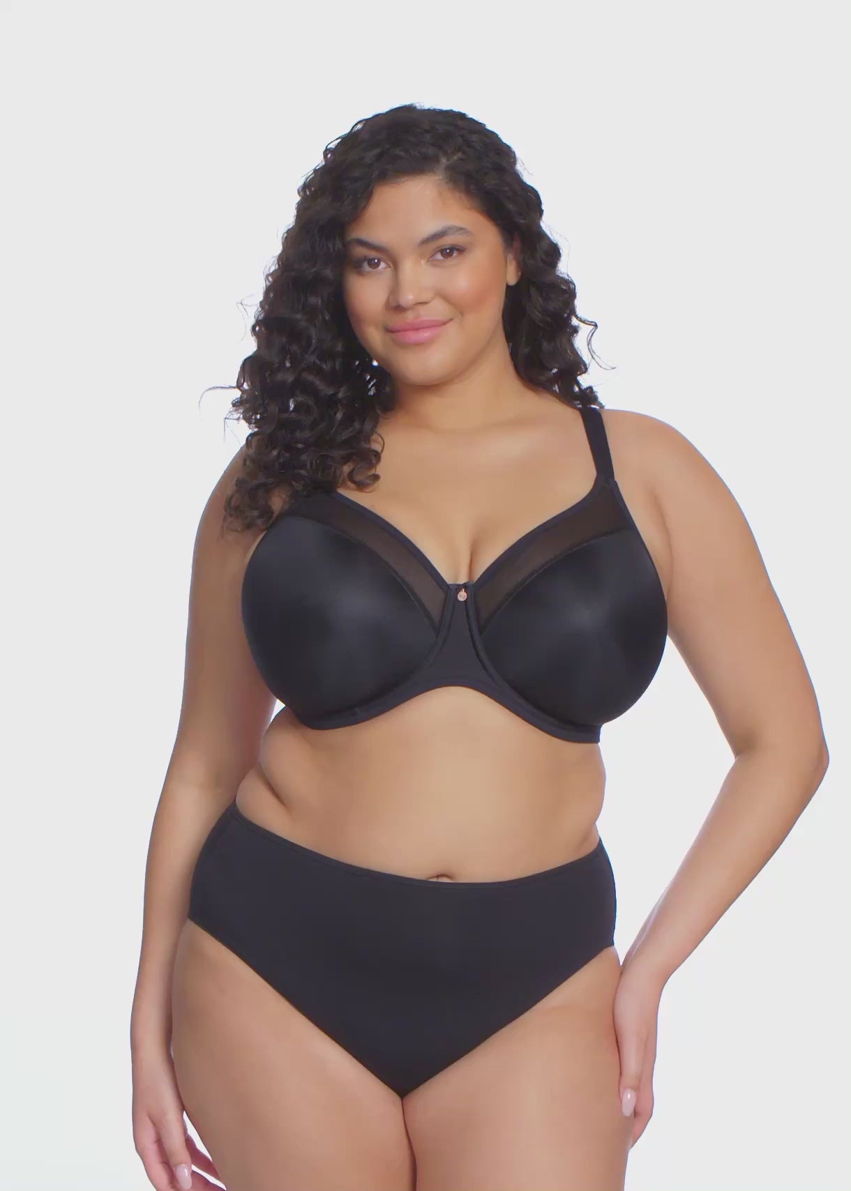 curvy woman wearing Black bra and high-waisted lingerie bottom on a white background