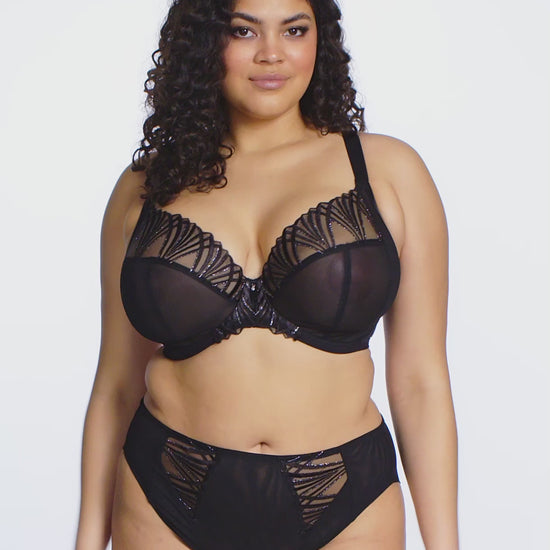curvy woman wearing black lingerie with geomatric lace pattern against a white background