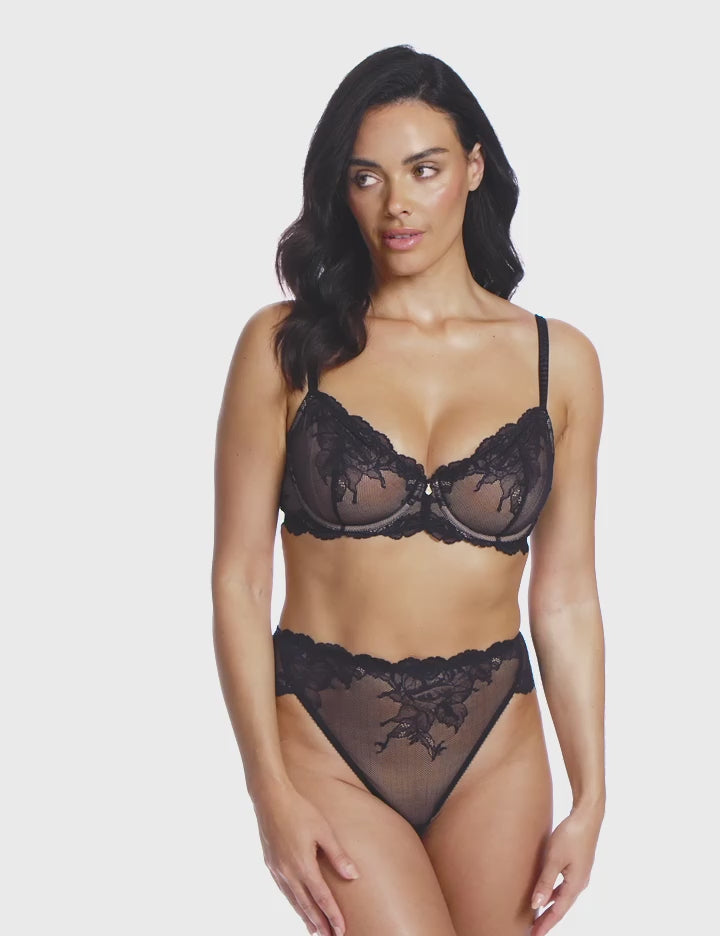 woman wearing a black lace bra with flower details with matching high leg brief