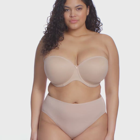 curvy woman wearing a beige strapless bra  against a white background