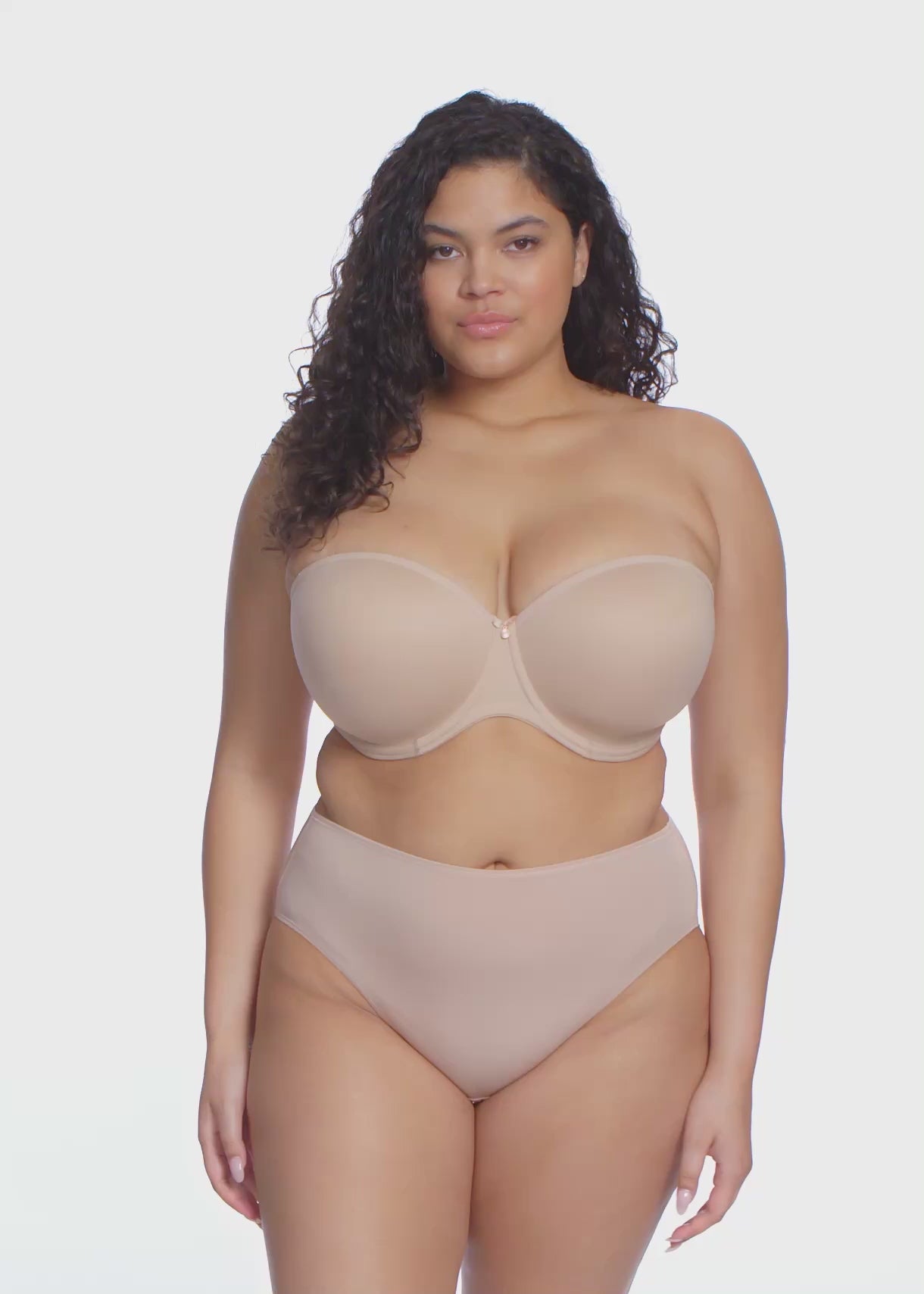 curvy woman wearing a beige strapless bra  against a white background