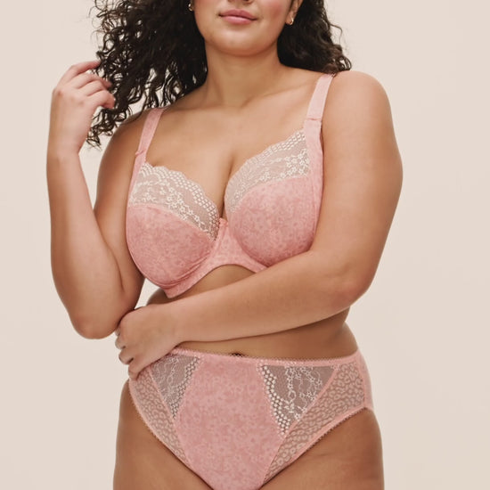 curvy woman wearing a big cup bra with flower pattern and lace in pink color