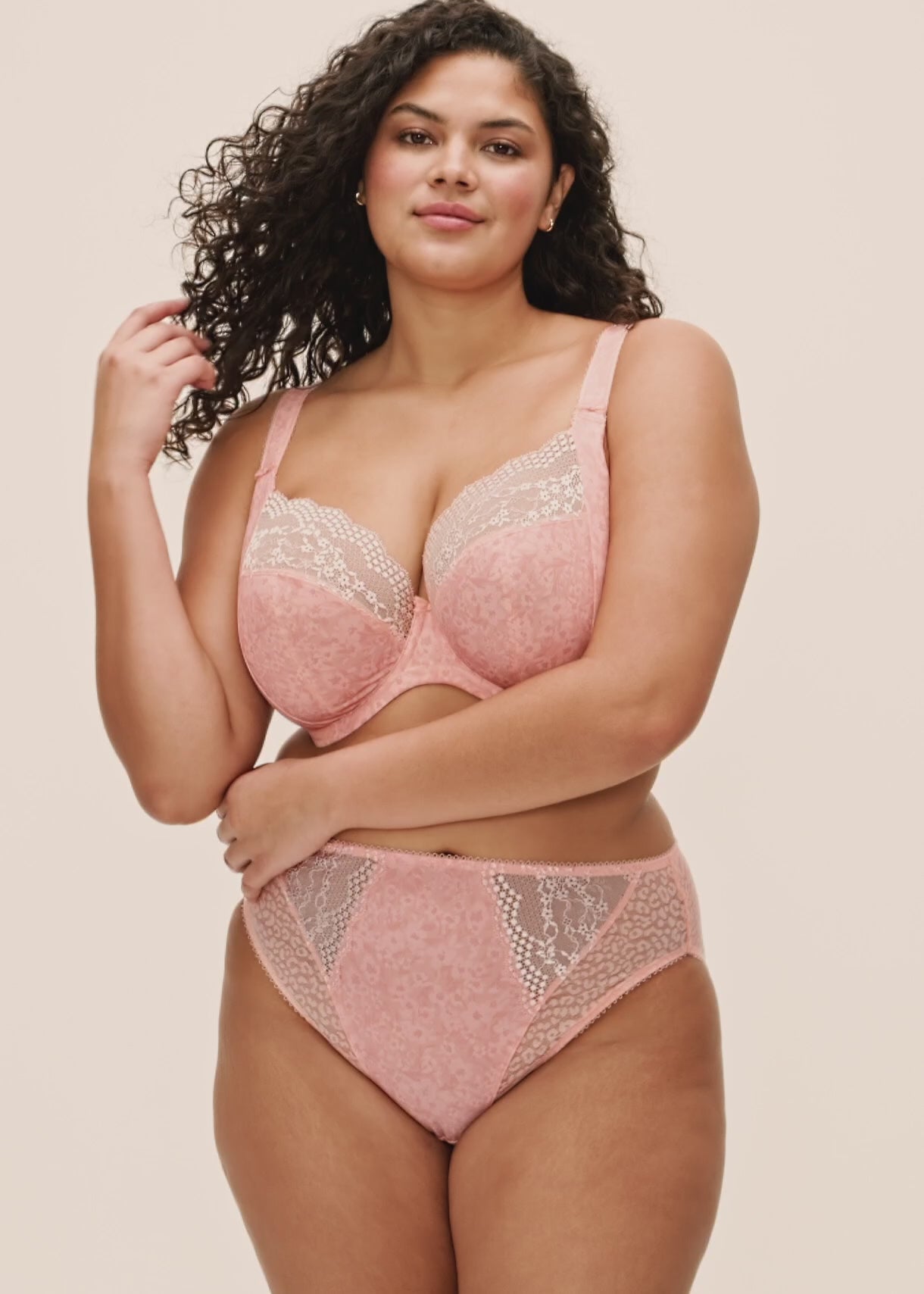 curvy woman wearing a big cup bra with flower pattern and lace in pink color