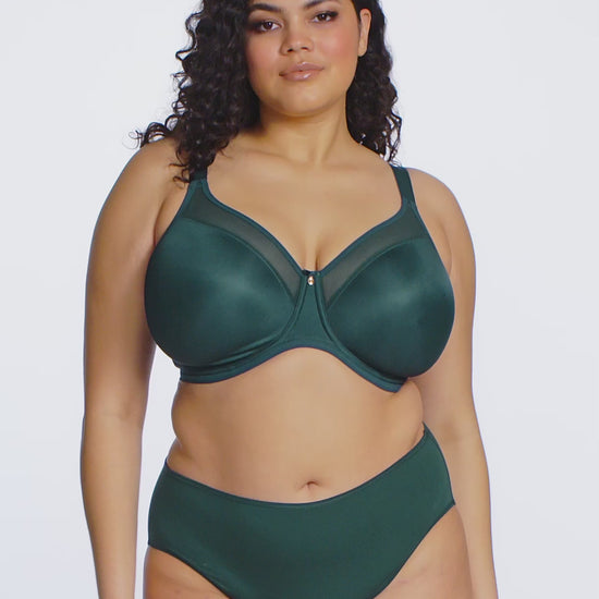 curvy woman wearing deep green lingerie against a white background
