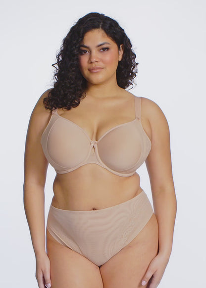 Curvy woman wearing beige lingerie against a white background