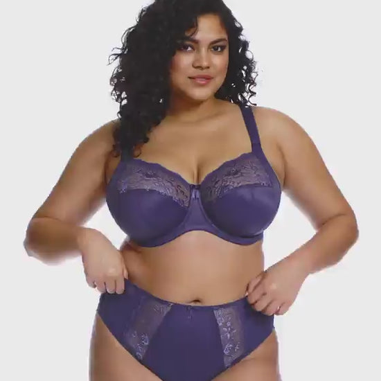 curvy woman wearing a blue lingerie set against a white background