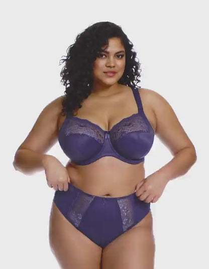 curvy woman wearing a blue lingerie set against a white background