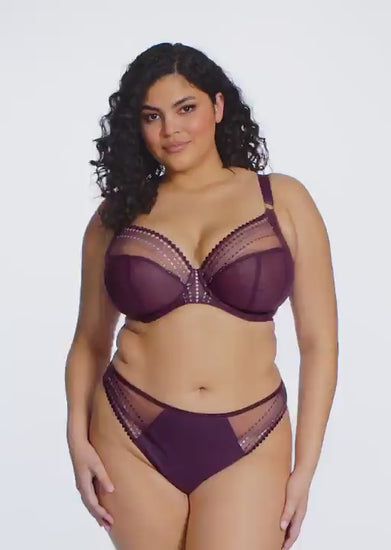 curvy woman wearing a purple lingerie bottom with lace trim on a white background