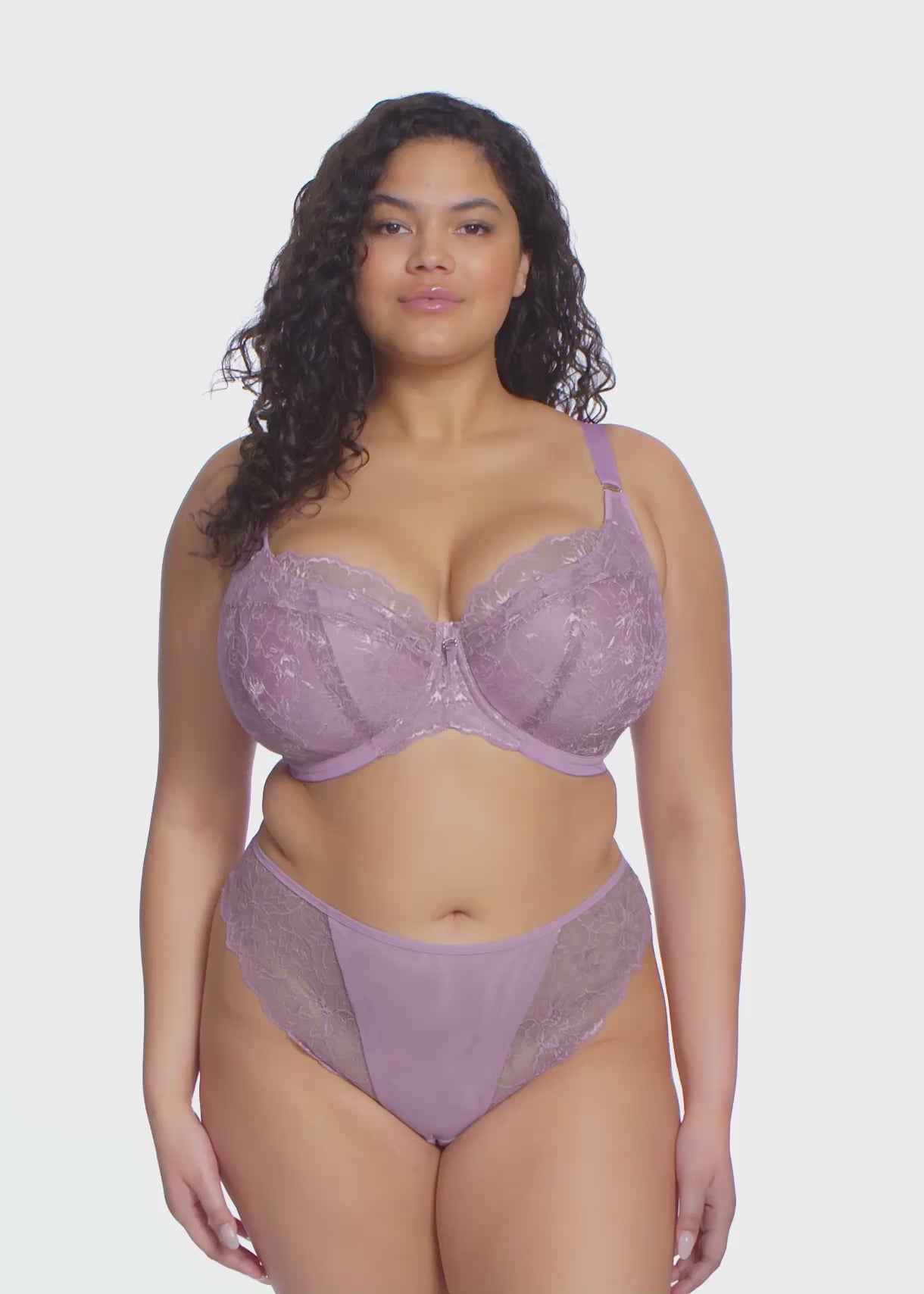 curvy woman wearing a padded big cup plunge bra in heather purple against a white background